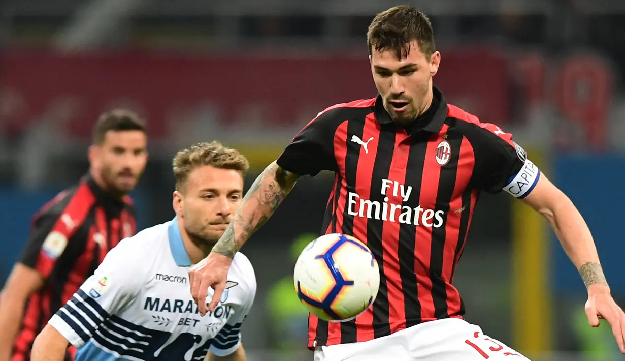 Bek AC Milan, Alessio Romagnoli berusaha mengontrol bola dari kejaran striker Lazio, Ciro Immobile selama pertandingan lanjutan Liga Serie A Italia di stadion San Siro (13/4). Milan menang tipis atas Lazio 1-0. (AFP Photo/Miguel Medina)