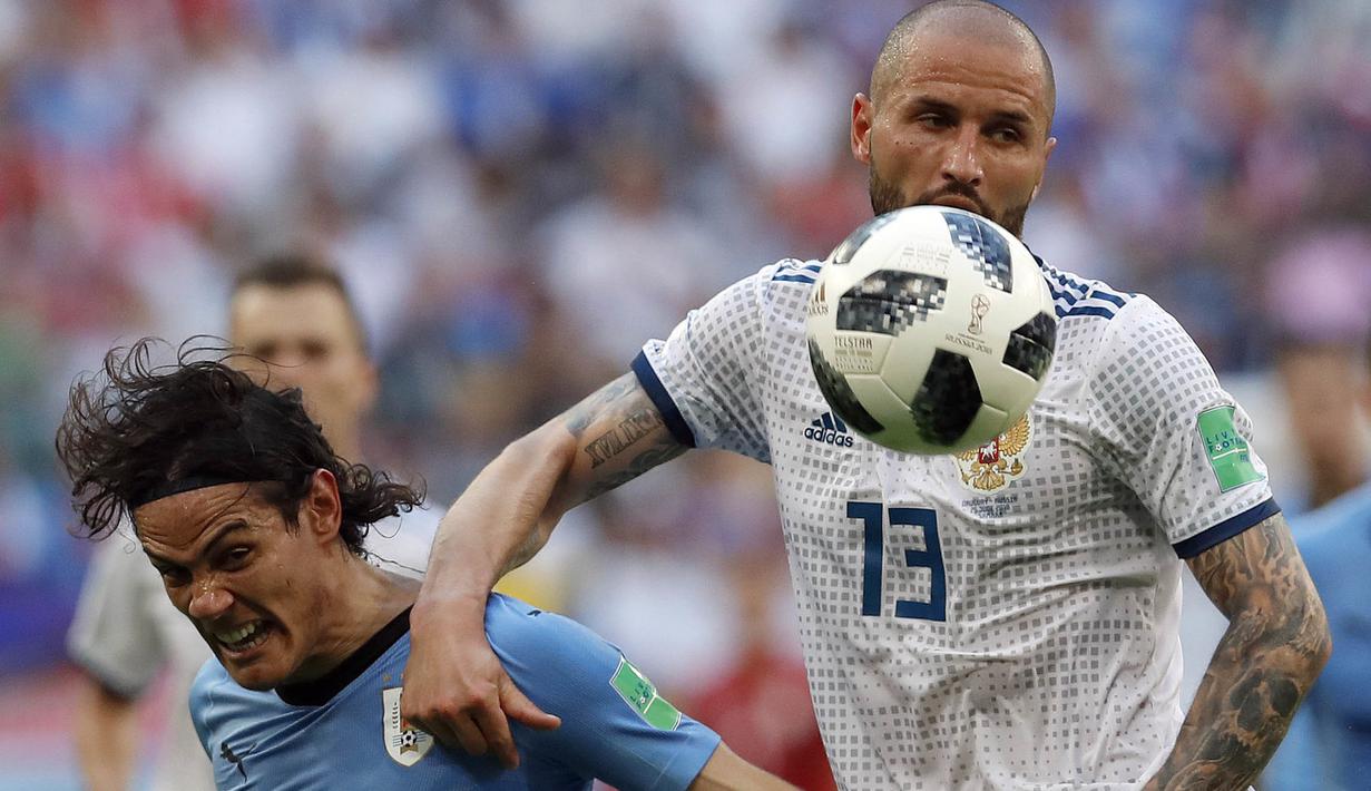 Duel pemain Uruguay, Edinson Cavani (kiri) dan pemain Rusia, Fyodor Kudryashov pada laga grup A Piala Dunia 2018 di Samara Arena, Samara, Rusia, (25/6/2018). Uruguay menang 3-0. (AP/Hassan Ammar)