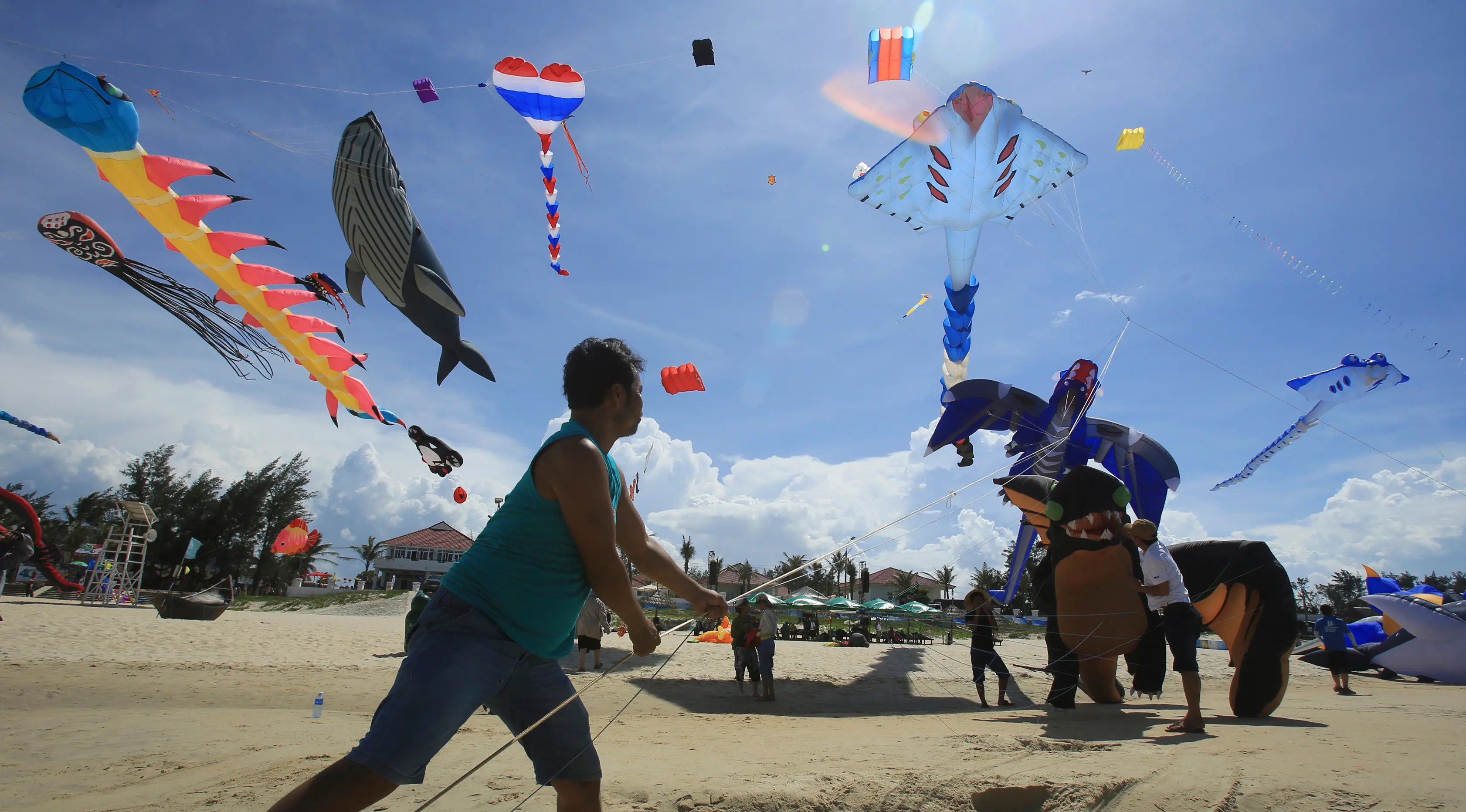 Seorang peserta menerbangkan layang-layangnya diatas pantai Tam Thanh selama Festival Internasional Kite di Quang Nam, Vietnam (11/6). Dalam festival ini, pengrajin menunjukan keterampilan membuat, serta menerbangkan layang-layangnya. (AP Photo/Hau Dinh)