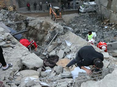 Tim penyelamat memeriksa reruntuhan bangunan setelah serangan udara Israel di desa Shebaa, Lebanon Selatan, pada 27 September 2024. (Rabih DAHER/AFP)
