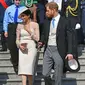 Duke dan Duchess of Sussex, Pangeran Harry dan Meghan Markle menghadiri pesta kebun Istana Buckingham di London, Selasa (22/5). Meghan juga memakai stocking warna kulit, mengikuti cara berbusana Putri Inggris lainnya. (Dominic Lipinski/Pool Photo via AP)