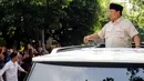 Dari sunroof mobilnya, Presiden Prabowo juga menyapa warga yang berkerumun di pinggir jalan. (Liputan6.com/Herman Zakharia)