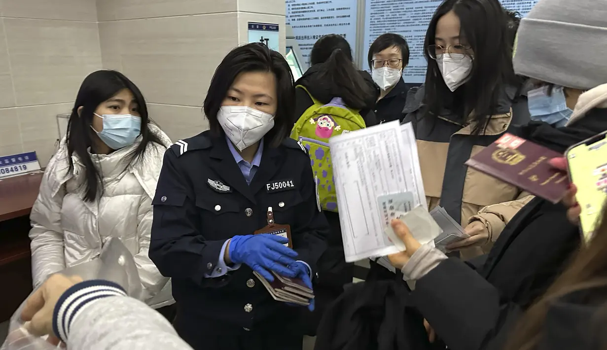 <p>Seorang petugas mengumpulkan paspor dari penduduk untuk perpanjangan dan pendaftaran ulang di kantor polisi komunitas di Beijing, China, Rabu (28/12/2022). China mengatakan akan melanjutkan penerbitan paspor untuk pariwisata dalam langkah besar lainnya dari kontrol anti-virus yang mengisolasi negara selama hampir tiga tahun, menyiapkan potensi banjir orang Cina pergi ke luar negeri untuk liburan Tahun Baru Imlek bulan depan. (AP Photo/Ng Han Guan)</p>