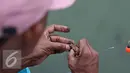 Seorang warga saat mempersiapkan umpan utk memancing ikan di Kali Tanjung Selor, Jakarta, Rabu (20/1). Dengan biaya murah Kali Tanjung Selor menjadi lokasi favorit bagi warga untuk memancing. (Liputan6.com/Immanuel Antonius)