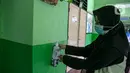 Seorang guru memakai sanitizer di SDN Kenari 08, Jakarta, Selasa (6/4/2021). Uji coba pembelajaran tatap muka terbatas di DKI Jakarta akan dilakukan dengan menerapkan protokol kesehatan COVID-19 yang ketat. (Liputan6.com/Faizal Fanani)
