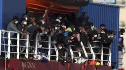 Migran berada di atas Kapal Sea Eye 4 saat tiba di Trapani, Sisilia, Italia, Minggu (7/11/2021). Kapal kemanusiaan Jerman diberikan izin oleh otoritas Italia setelah berhari-hari menunggu di Laut Mediterania. (Alberto Lo Bianco/LaPresse via AP)
