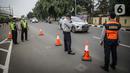 Petugas mengawasi kendaraan yang melintasi pos cekpoin penyekataan arus mudik di kawasan Pasar Jumat, Kamis (6/5/2021). Penyekatan dan cek poin dilakukan saat penerapan larangan mudik Lebaran 2021 sebagai upaya pencegahan penularan COVID-19. (Liputan6.com/Faizal Fanani)