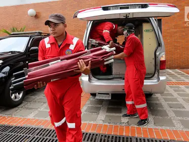 Petugas Airport Rescue & Fire Fighting Officer menurunkan tandu lipat di Gedung VIP Terminal 1B, Bandara Internasional Soekarno-Hatta, Tangerang, Senin (29/10). Sebanyak 20 tandu lipat digunakan untuk pengambilan antemortem. (Liputan6.com/Fery Pradolo)