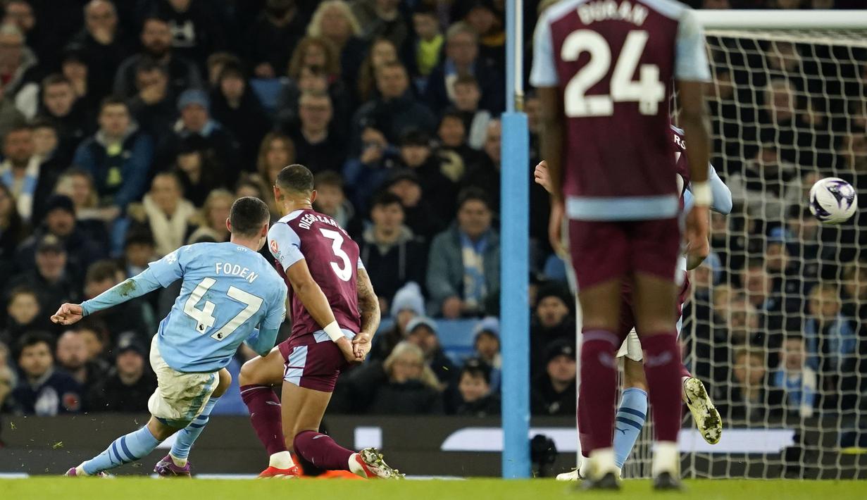 Gelandang Manchester City, Phil Foden (kiri) mencetak gol keempat timnya ke gawang Aston Villa pada laga pekan ke-31 Premier League 2023/2024 di Etihad Stadium, Manchester, Rabu (3/4/2024) malam. (AP Photo/Dave Thompson)