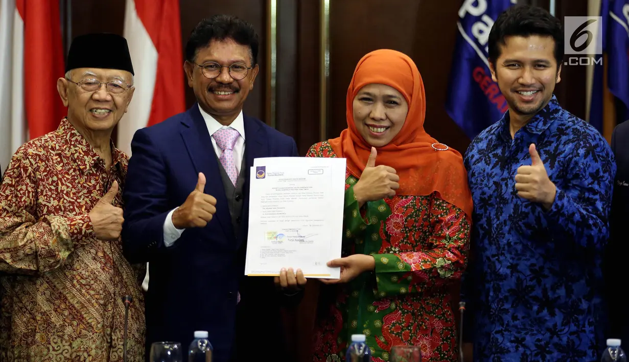 Balon Gubernur dan Wagub Jawa Timur, Khofifah Indar Parawansa (kedua kanan) dan Emil Dardak (kanan) menunjukkan Surat Persetujuan Pasangan Cagub dan Cawagub dari DPP Partai Nasdem di Kantor Partai Nasdem, Jakarta, Selasa (2/1). (Liputan6.com/Johan Tallo)