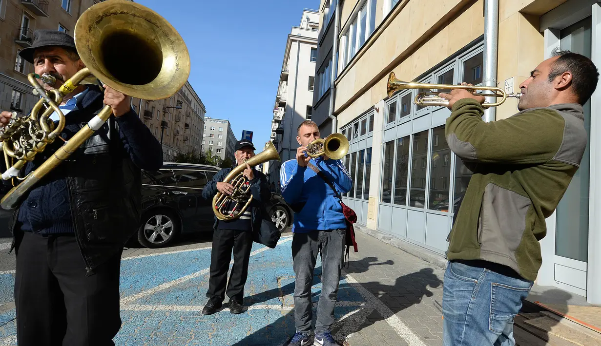 Aksi orkes tiup musisi Rumania untuk mendapat uang di jalanan Warsawa, Polandia pada 21 Oktober 2019. Orkes tiup yaitu sekelompok orang yang memperagakan musik dengan menggunakan instrumen musik tiup baik tiup logam maupun tiup kayu.  (AP Photo/Czarek Sokolowski)