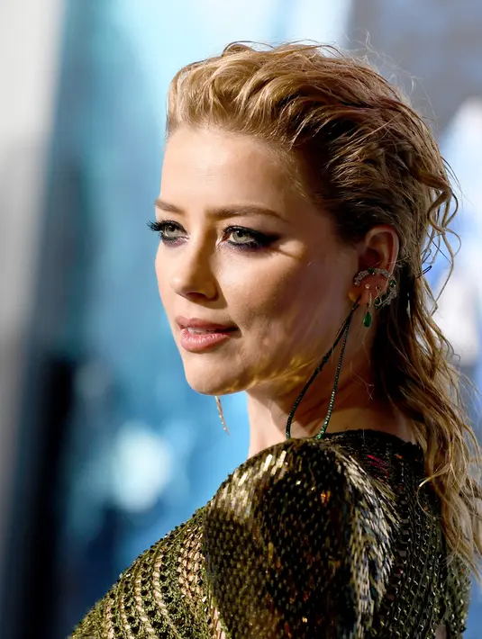 Ekspresi Amber Heard saat menghadiri premier film terbarunya, "Aquaman" di Los Angeles, California, AS (12/12). Amber Heard tampil seksi dengan gaun jaring-jaring menerawang hijau. (AFP Photo/Kevin Winter)