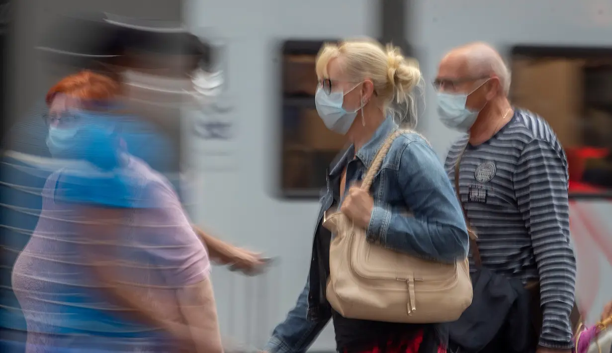 Penumpang berjalan di sepanjang peron di stasiun kereta utama di Frankfurt, Jerman, Jumat (14/8/2020). Mengenakan masker untuk melindungi diri dari corona Covid-19 adalah kewajiban di transportasi umum di Jerman. (AP Photo/Michael Probst)