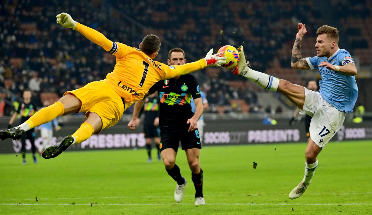 Kiper Inter milan, Samir Handanovic (kiri) berebut bola dengan pemain Lazio, Ciro Immobile pada laga lanjutan Liga Italia 2021/2022 di Giuseppe Meazza, Milan, 9 Januari 2022. (AFP/Miguel Medina)