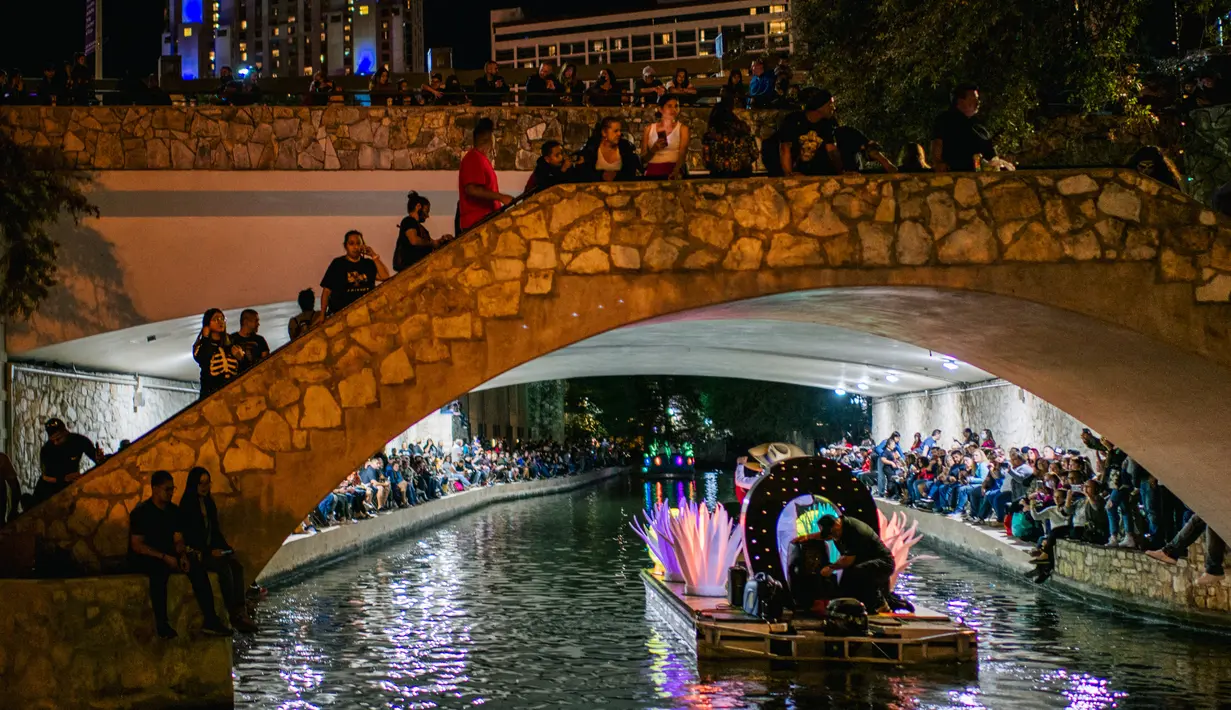 Warga melihat kendaraan hias melintas selama parade Hari Sungai Mati di San Antonio, Texas, Amerika Serikat, 29 Oktober 2021. Warga berkumpul untuk merayakan, memperingati, dan mengenang orang-orang terkasih yang telah meninggal untuk Día de los Muertos tahun ini. (Brandon Bell/Getty Images/AFP)