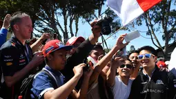 Pebalap Manor F1 Team, Rio Haryanto melayani foto selfie bersama fans sebelum balapan perdana Formula One Australian Grand Prix, Melbourne, Minggu (20/3/2016). (AFP/Paul Crock)