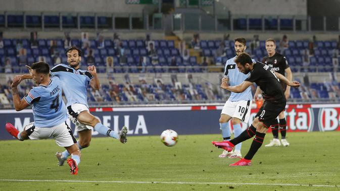 Pemain AC Milan Hakan Calhanoglu (kanan) mencetak gol ke gawang Lazio pada pertandingan Serie A di Olympic Stadium, Roma, Italia, Sabtu (4/7/2020). AC Milan mengalahkan Lazio dengan skor 3-0. (AP Photo/Riccardo De Luca)