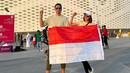 Meski tak mampu menembus Piala Dunia, bendera Indonesia nyatanya masih berkibar di Qatar. Pasangan selebriti itu mengibarkan bendera Merah Putih di kawasan stadion. (Liputan6.com/IG/@darius_sinathrya)