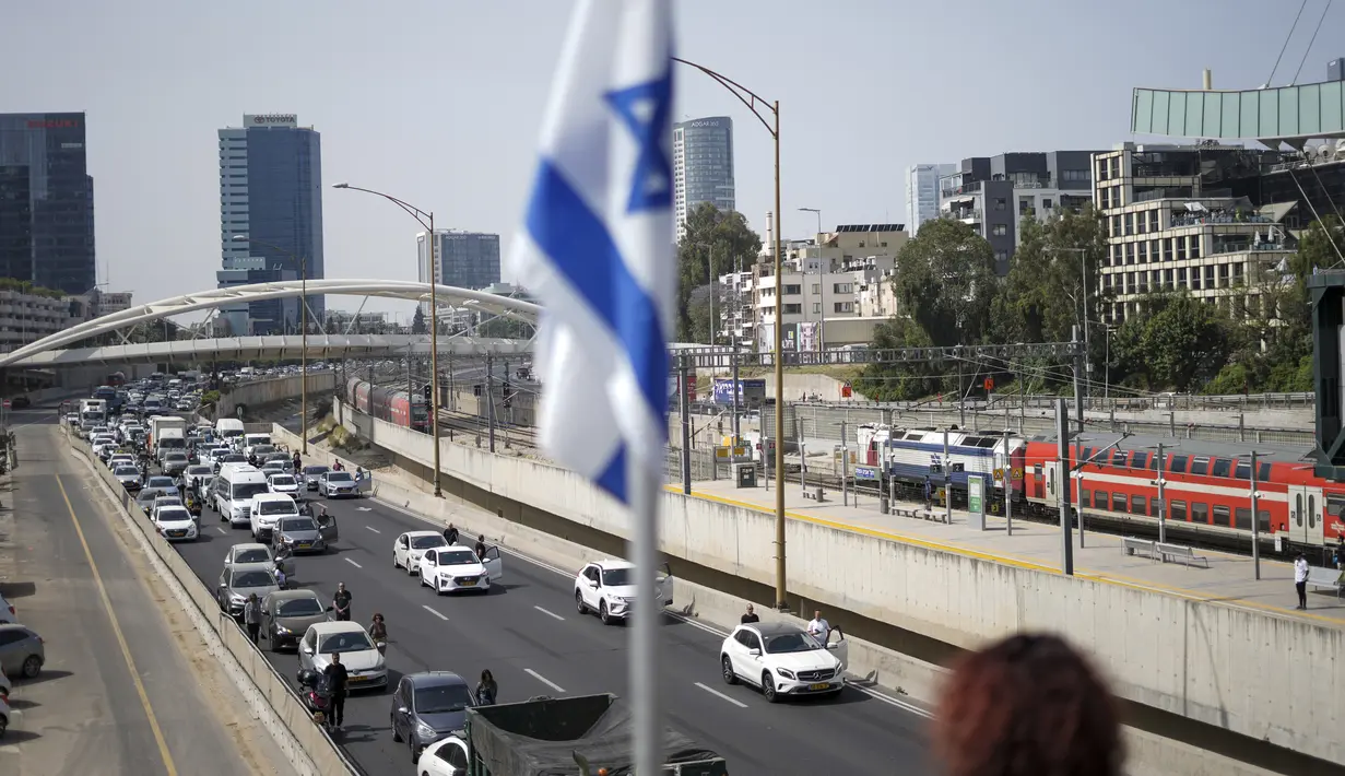 <p>Warga Israel berdiri diam di samping mobil mereka di jalan bebas hambatan saat sirene dua menit berbunyi untuk mengenang para korban Holocaust di Tel Aviv, Israel, 28 April 2022. Hari Peringatan Holocaust adalah salah satu yang paling khusyuk dalam kalender Israel. (AP Photo/Ariel Schalit)</p>