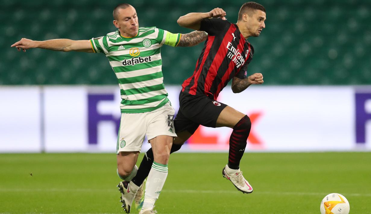Gelandang AC Milan, Rade Krunic, Berebut bola dengan gelandang Celtic, Scott Brown, pada laga Grup H Liga Europa 2020/2021 di Celtic Park Stadion, Jumat (23/10/2020). AC Milan menang 3-1 atas Celtic. (AFP/Russell Cheyne/pool)