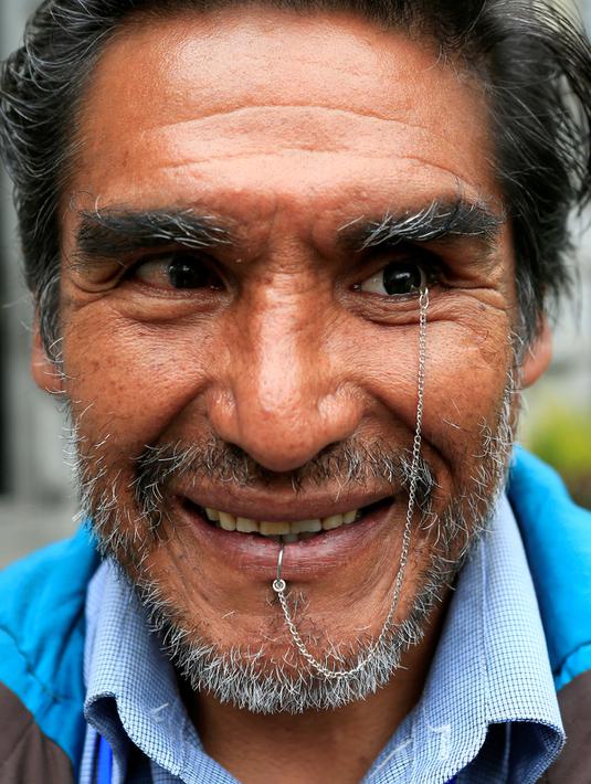 Senyum Edwin Morales saat  berpose menunjukan mata palsunya di La Paz, Bolivia (12/4). Edwin merupakan satu dari ratusan penyandang cacat di Bolivia yang menuntut Presiden Bolivia Evo Morales. (REUTERS/David Mercado)