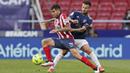 Pemain Atletico Madrid, Angel Correa, berusaha melewati pemain Osasuna, Ruben Garcia, pada laga Liga Spanyol di Stadion Wanda Metropolitano, Minggu (16/5/2021). Atletico Madrid menang dengan skor 2-1. (AP/Manu Fernandez)