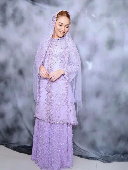 Ikut mendampingi Syifa di acara pengajian, Ayu Ting Ting tampil begitu memesona. Hot mom satu anak itu tampak begitu anggun dalam balutan busana dan kerudung warna ungu berhiaskan payet. (Instagram/kriznafahrezi).