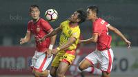 Pemain Bhayangkara FC, Ilham Udin mengontrol bola saat melewati dua pemain Persija Jakarta pada lanjutan Liga 1 2017 di Stadion Patriot Bekasi, Sabtu (12/11/2017). Bhayangkara kalah dari Persija 1-2. (Bola.com/Nicklas Hanoatubun)