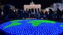 Sejumlah lilin dinyalakan dan dibentuk seperti dunia sebelumnya aksi Earth Hour Internasional di Berlin, Jerman (25/3). Kegiatan ini dilakukan dalam rangka memperingati hari bumi atau lebih dikenal dengan Earth Hour ke-10 atau 2017. (AFP/dpa/Paul Zinken)