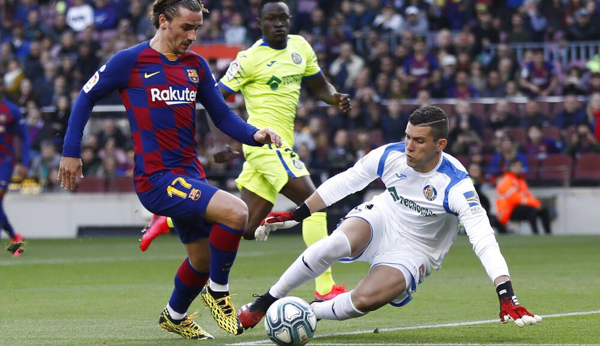 Penyerang Barcelona, Antoine Griezmann, berusaha melewati kiper Getafe, David Soria, pada laga La Liga di Stadion Camp Nou, Sabtu (15/2/2020). Barcelona menang 2-1 atas Getafe. (AP/G.Garin)