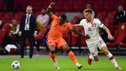 Penyerang Belanda, Steven Bergwijn, berebut bola dengan penyerang Polandia, Krzysztof Piatek, pada laga UEFA Nations League di Stadion Johan Cruijff Arena, Amsterdam, Sabtu (5/9/2020) dini hari WIB. Belandang menang 1-0 atas Polandia. (AFP/John Thys)