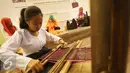 Peserta menenun saat pemeran bertajuk Karya Kreatif Indonesia di Jakarta, Jumat (26/8). Pameran tersebut diselenggarakan dalam rangka mempromosikan produk Usaha Mikro Kecil Menengah (UMKM) dari seluruh Indonesia. (Liputan6.com/Immanuel Antonius)