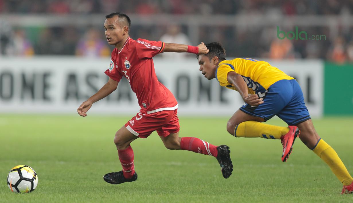 Pemain Persija Jakarta, Riko Simanjuntak (kiri) melewati adangan pemain Tampines Rovers pada laga Piala AFC 2018 di Stadion Utama GBK, Senayan, Jakarta (28/2/2018). Persija menang 4-1. (Bola.com/Nick Hanoatubun)