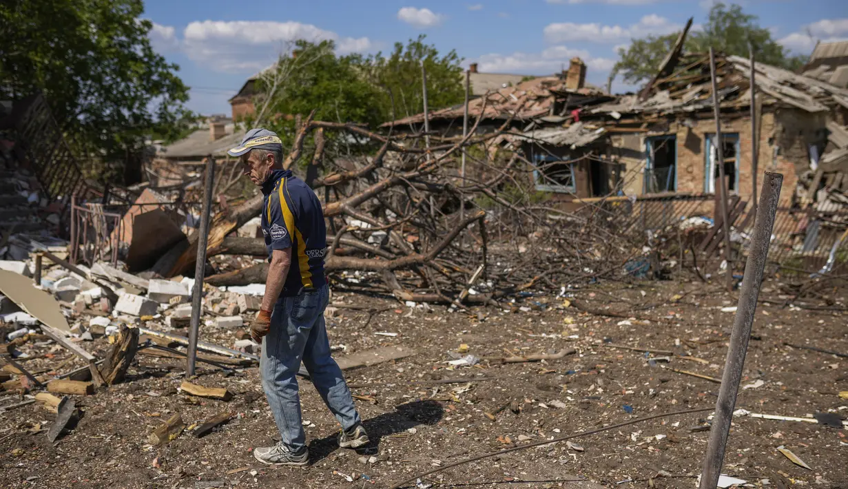 <p>Seorang penduduk setempat berdiri di samping sebuah rumah yang hancur dalam pemboman Rusia di Bakhmut, Ukraina timur, Selasa (24/5/2022). Kota Bakhmut telah mengalami peningkatan serangan artileri, terutama selama seminggu terakhir, ketika pasukan Rusia mencoba untuk terus maju mengepung kota Sieverodonetsk di timur laut. (AP Photo/Francisco Seco)</p>