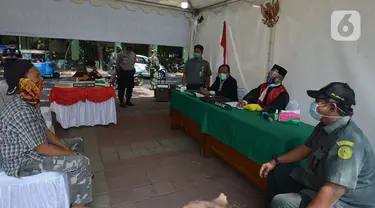 Pelanggar mengikuti sidang di tempat saat Operasi Yustisi di Kawasan Danau Sunter, Jakarta, Rabu (16/9/2020). Warga yang melanggar protokol Covid-19 langsung disidang tindak pidana ringan (tipiring) di tempat dengan membayar denda Rp 55.000 maupun sanksi sosial. (merdeka.com/Imam Buhori)