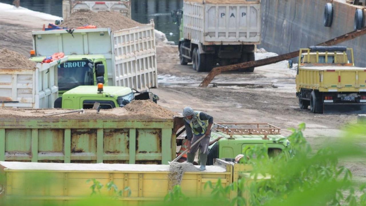 Pekerja meratakan pasir di atas truk angkut di Kawasan Marunda, Jakarta, Selasa (30/4/2024). Wakil Ketua Umum Asosiasi Pemasok Energi, Mineral, dan Batubara Indonesia (Aspebindo) Fathul Nugroho mengatakan, ekspor pasir laut berpotensi merusak lingkungan h