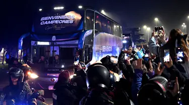 Para penggemar mengambil gambar bus yang mengangkut tim sepak bola nasional Argentina di Ezeiza, Buenos Aires, Argentina pada 15 Juli 2024. (Luis ROBAYO/AFP)