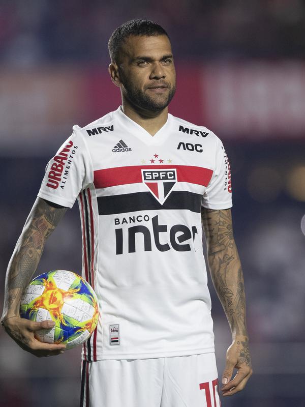 Ekspresi Dani Alves saat diperkenalkan sebagai bek baru Sao Paulo di stadion Morumbi, Brasil (6/8/2019). Mantan pemain Barcelona dan Juventus berusia 36 tahun ini dikontrak selama tiga musim, atau hingga 2022. (AP Photo/Andre Penner)