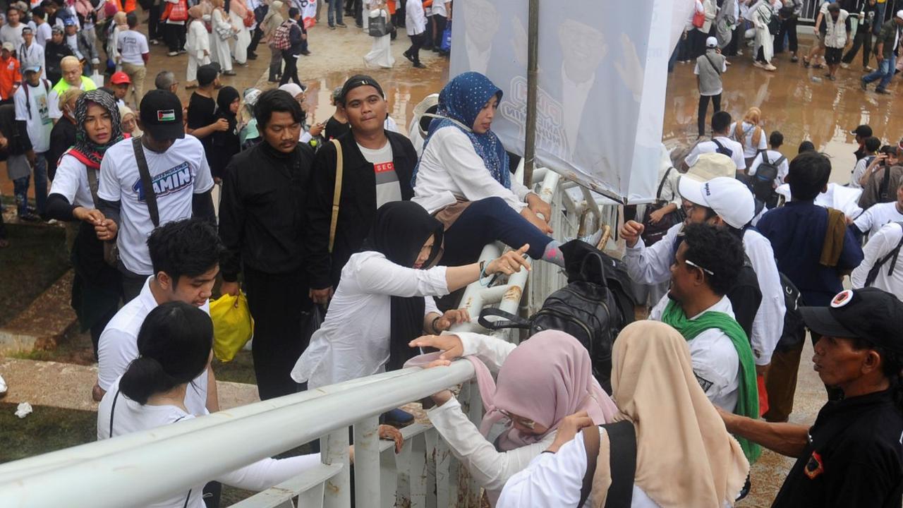 Akibat padatnya akses masuk tersebut, tak sedikit pendukung nomor urut 01 ini terpaksa harus berjalan kaki sejauh 3 sampai 5 kilometer untuk bisa masuk ke dalam Jakarta International Stadium (JIS). Foto: merdeka.com / Arie Basuki