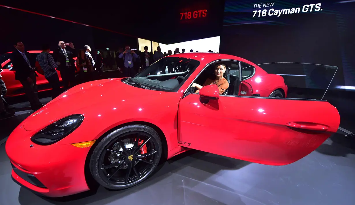 Petenis Maria Sharapova tersenyum saat berpose di dalam mobil Porsche 718 Cayman GTS selama pameran mobil AutoMobility LA di Los Angeles Convention, California (29/11). Sharapova tampil cantik dengan gaun berwarna coklat. (AFP/Kevork Djansezian)