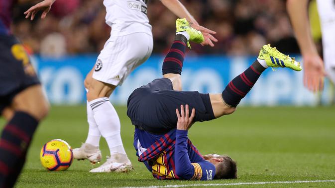 Pemain Barcelona, Lionel Messi terjatuh saat bertanding melawan Valencia dalam lanjutan Liga Spanyol di Camp Nou, Spanyol, Minggu (3/2). Dua gol Messi membuat pertandingan berakhir 2-2. (AP Photo/Manu Fernandez)