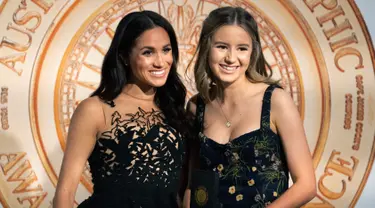 Meghan Markle (kiri) berpose bersama Sophia Skarparis usai memberi penghargaan selama Australian Geographic Awards di Sydney, Australia (26/10). Meghan tampil cantik mengenakan gaun mewah Oscar de la Renta. (Paul Edwards/Pool via AP)