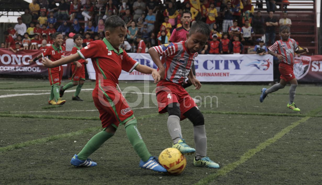 Tim ATKL Tigers Malaysia berebut bola dengan pemain CISS (merah) dalam final Plate U-8 Serpong City International Soccer Tournament di Sabnani Park, Tangerang Selatan. Minggu (4/12/2016). (Bola.com/Arief Bagus)