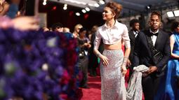 Penampilan Zendaya saat menghadiri Academy Awards ke-94 atau disebut juga Piala Oscar 2022 di Hollywood, California, Minggu (27/3/2022). Zendaya tampil memukai mengenakan kemeja crop satin sutra dan rok metalik bling-bling. (Emma McIntyre/Getty Images/AFP)