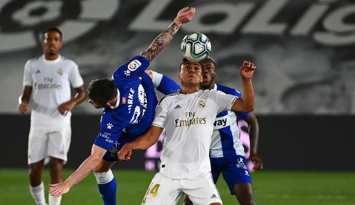 Gelandang Real Madrid, Casemiro, berebut bola dengan gelandang Alaves, Oliver Burke, pada laga lanjutan La Liga pekan ke-35 di Stadion Alfredo di Stefano, Sabtu (11/7/2020) dini hari WIB. Real Madrid menang 2-0 atas Alaves. (AFP/Gabriel Bouys)