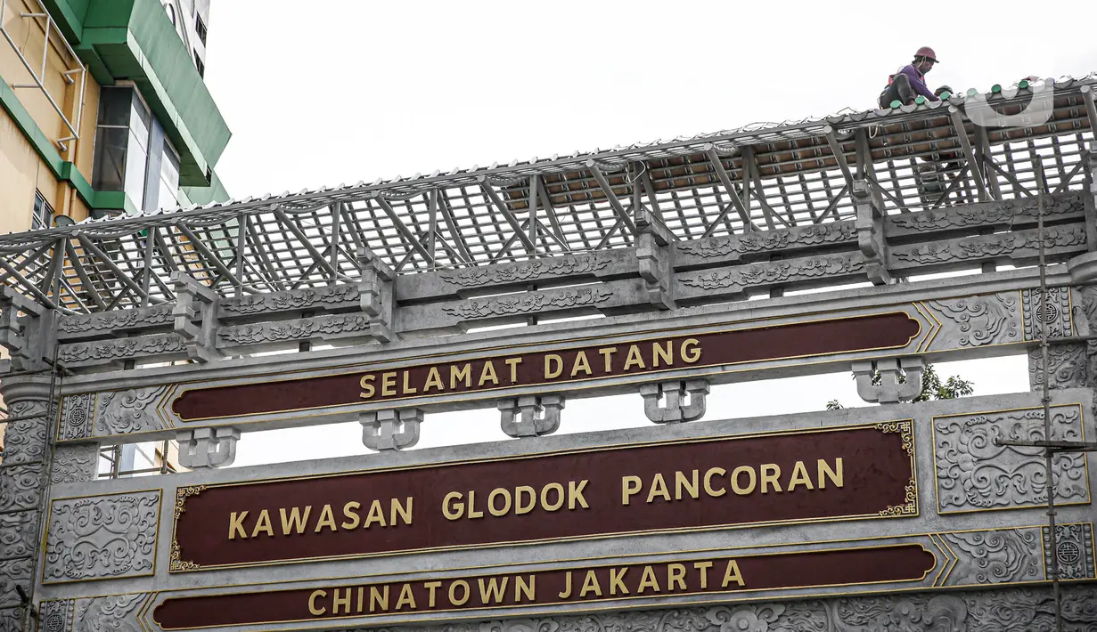 Sejumlah pekerja membangun gapura di Jalan Pancoran, Jakarta, Sabtu (11/6/2022). Pembangunan gapura tersebut bertujuan mempercantik kawasan Chinatown (Pecinan) Glodok Pancoran. (Liputan6.com/Faizal Fanani)