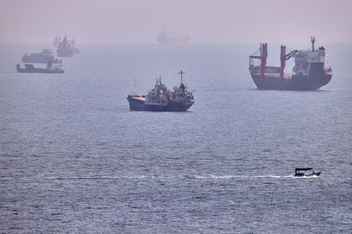 Sebuah perahu kecil berlayar melewati kapal kargo dan kapal komersial lainnya yang sedang berlabuh di Selat Hormuz, di lepas pantai Bandar Abbas, Iran, Rabu, 5 Agustus 2026. (Amirhosein Khorgooi/ISNA via AP)