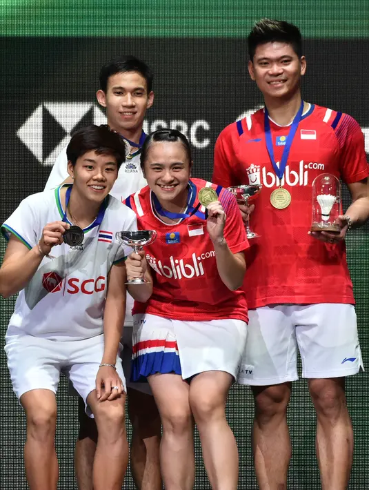 Pasangan Indonesia Praveen Jordan/Melati Daeva Oktavianti dan pasangan Thailand Dechapol Puavaranukroh/Sapsiree Taerattanachai memamerkan medali usai laga final ganda campuran All England 2020 di Birmingham, Inggris, Minggu (15/3/2020). Indonesia menang 21-15, 17-21, 21-8. (AP Photo/Rui Vieira)