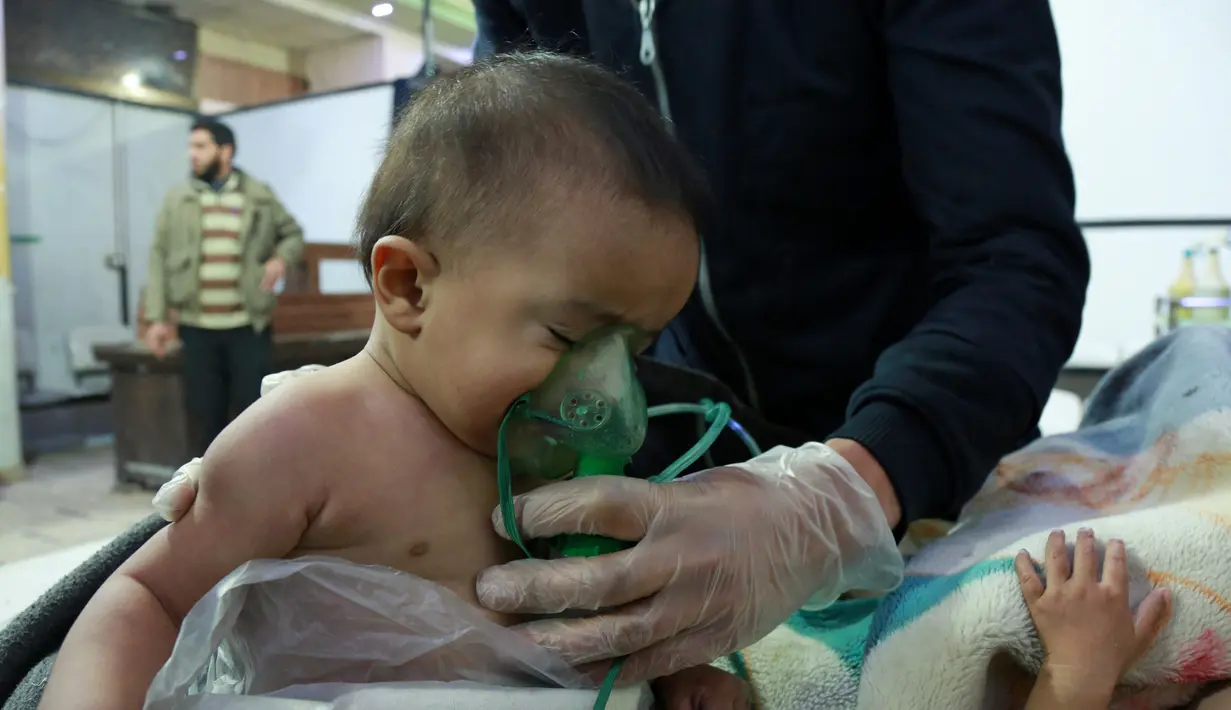 Seorang bayi mendapat bantuan pernapasan usai menghirup senjata kimia di Al-Shifuniyah, Ghouta Timur, Damaskus, Suriah, Minggu (25/2). (HAMZA AL-AJWEH/AFP)