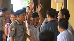 Wartawan Reuters, Kyaw Soe Oo (tengah) dikawal oleh polisi setibanya di pengadilan distrik Yangon, Myanmar, Senin (3/9). Dua jurnalis Reuters dituduh melanggar undang-undang rahasia negara saat menyelidiki kekerasan terhadap Rohingya. (AP/Thein Zaw)